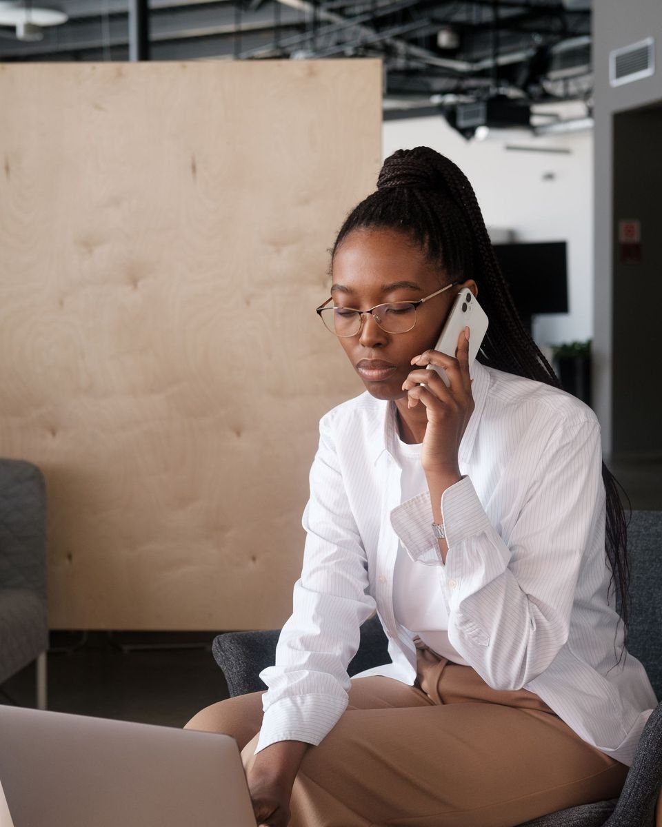 Business owner on a call with a customer while working on her laptop