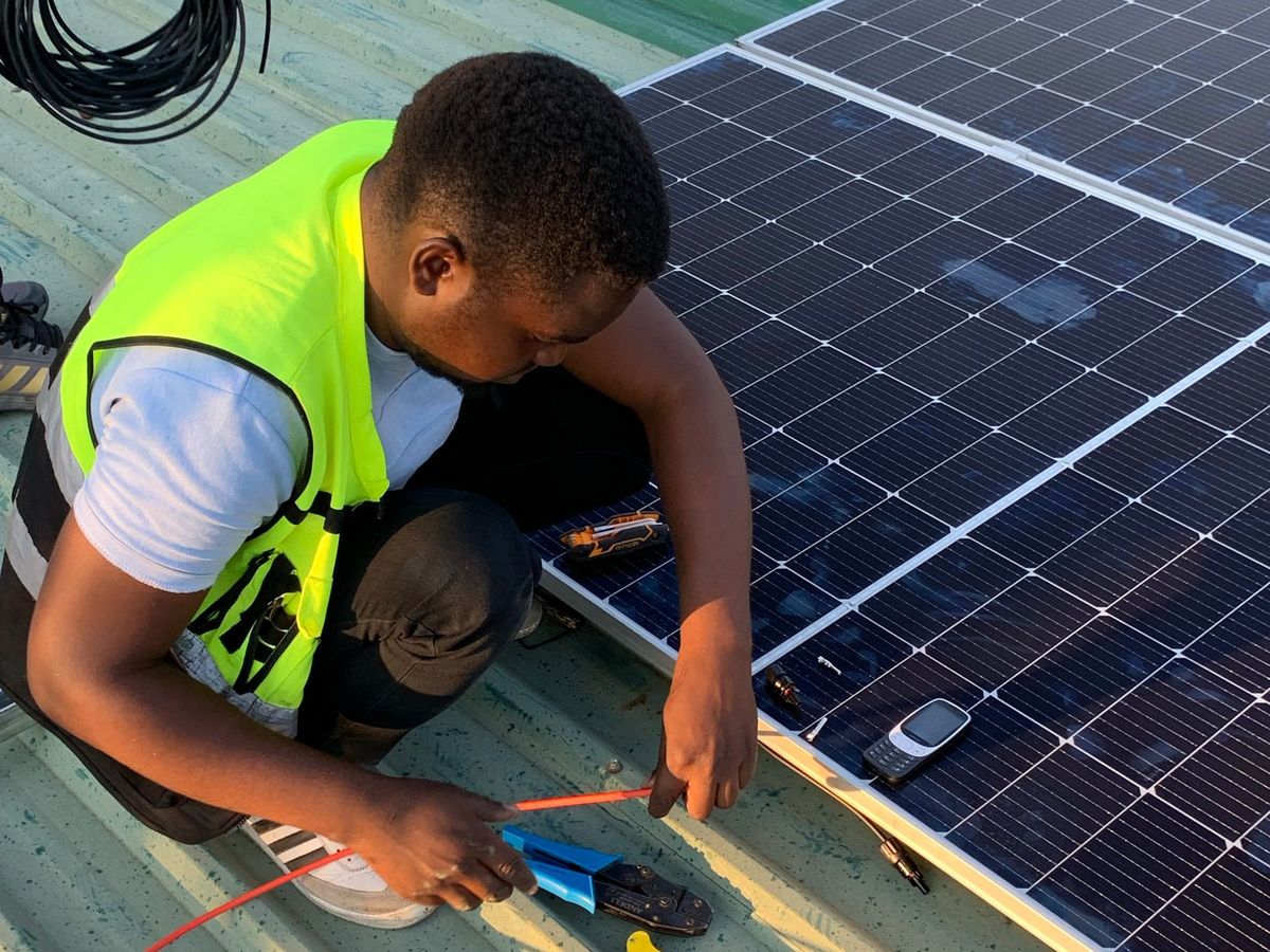 Solar technician installing panels on a rooftop